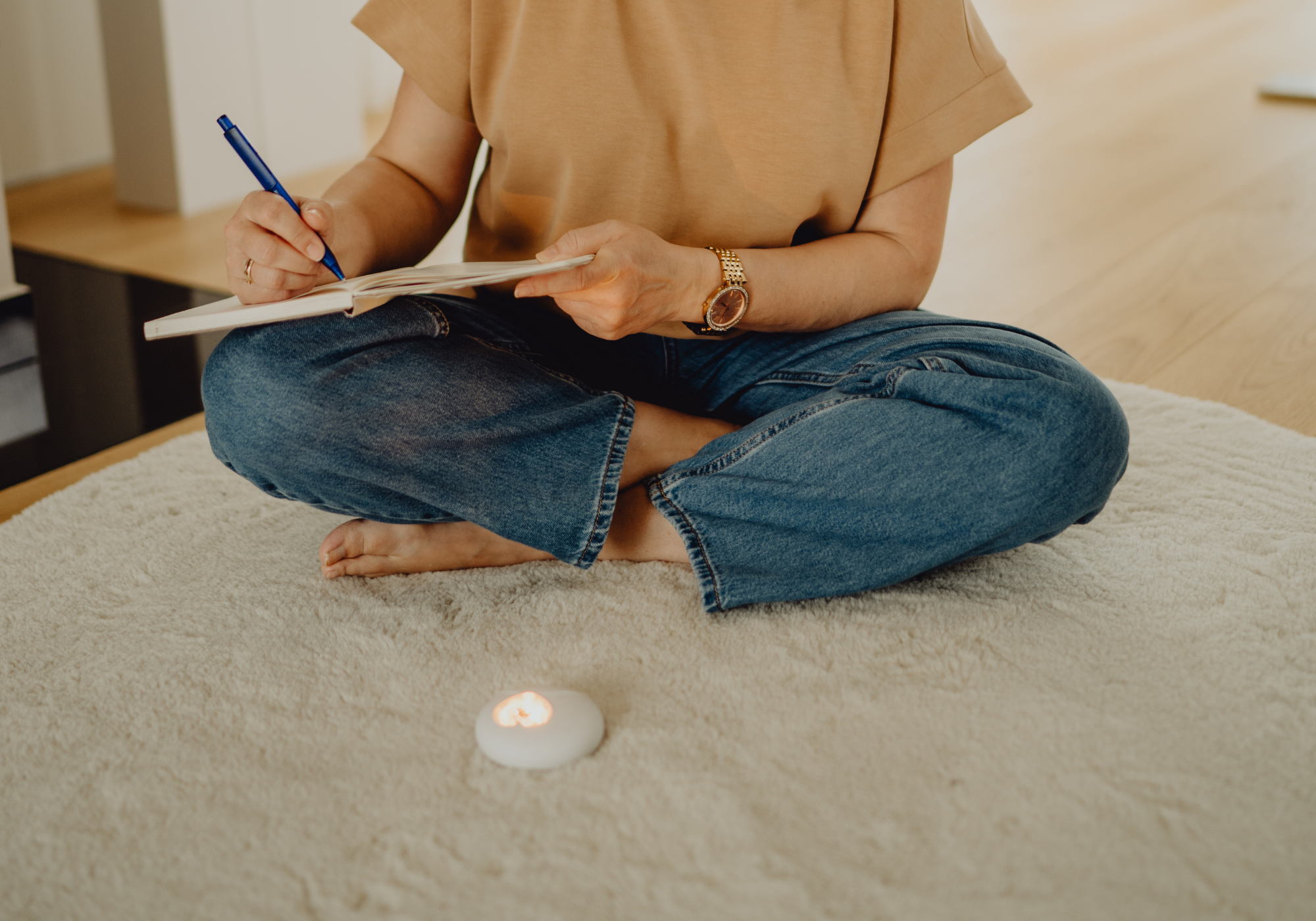 Eine Frau füllt ihr Tagebuch aus. Das HerzLicht liegt vor ihr und sorgt für eine visuelle Umrahmung ihrer Journaling-Routine.