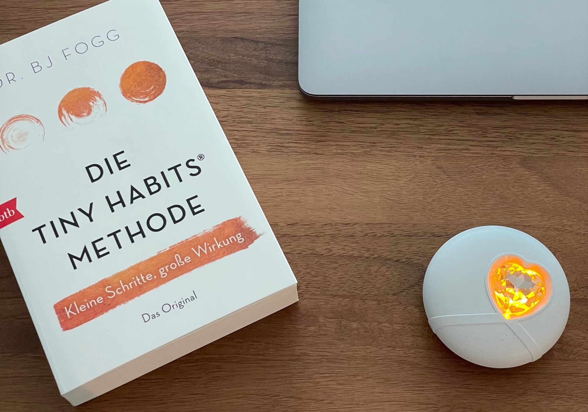 Das HerzLicht liegt neben dem Buch "Die Tiny Habits Methode".